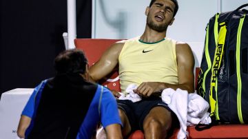 Carlos Alcaraz se lamenta al ser atendido por la lesión de tobillo que sufrió en el Rio Open 2024.
