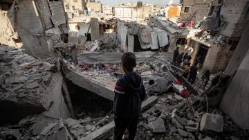 Un niño observa una zona destruida tras un ataque aéreo israelí contra el campo de refugiados de Rafah.