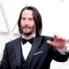 Keanu Reeves posando en una alfombra roja.