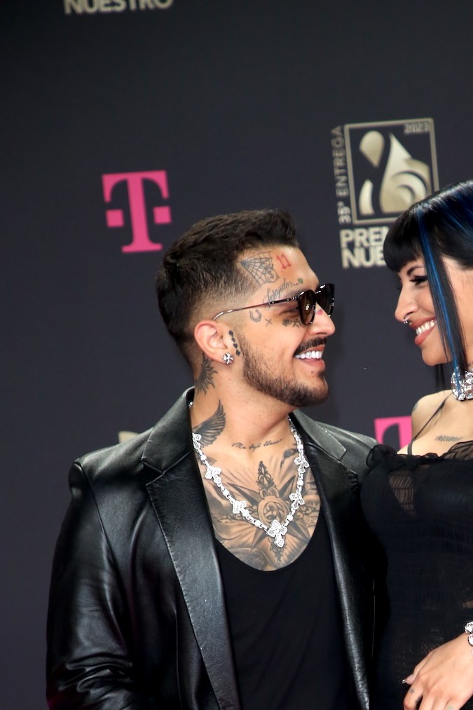 Christian Nodal y Cazzu posando en una alfombra roja.