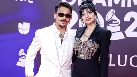 Christian Nodal y Cazzu posando en una alfombra roja.