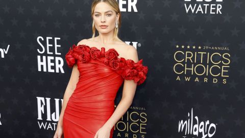 Margot Robbie posando en una alfombra roja.