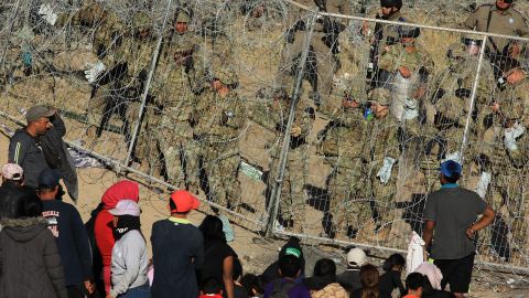 Personal de la Guardia Nacional estadounidense refuerzan una cerca de navajas y púas.