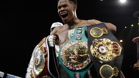 Devin Haney posa con sus títulos como campeón unificado de peso ligero.