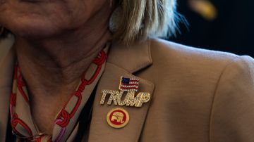 Un miembro del Comité Nacional Republicano, lleva un pin en apoyo al expresidente Donald Trump.