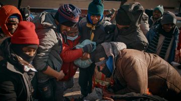 Los migrantes luchan por conseguir ropa, mientras grupos de ayuda mutua distribuyen alimentos y prendas para el clima frío.