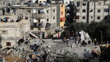 Los palestinos observan la destrucción tras un ataque israelí contra un edificio residencial en Rafah.