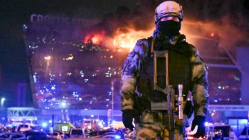 Un militar ruso de la Guardia Nacional asegura un área mientras se ve un incendio masivo sobre el Ayuntamiento de Crocus en el extremo occidental de Moscú.