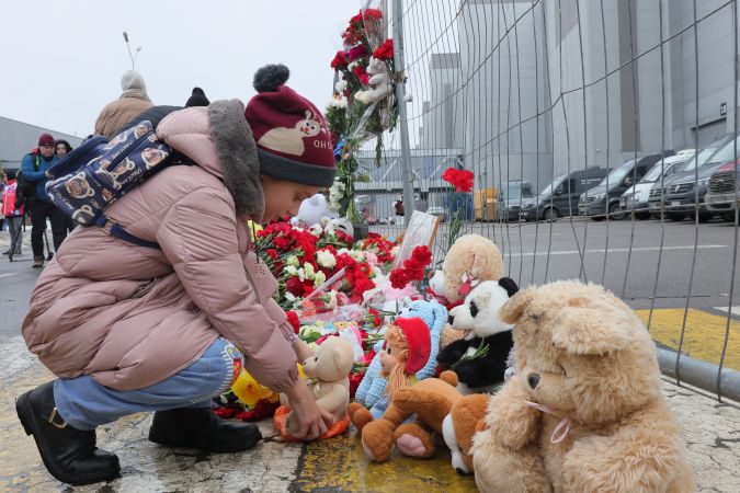 Un niño coloca un juguete en la valla junto al Ayuntamiento de Crocus, en el extremo occidental de Moscú, Rusia, tras un ataque atribuido a ISIS.