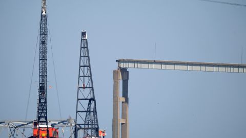 Barcazas con grúas flotan cerca de una sección dañada del puente Francis Scott Key en Baltimore.