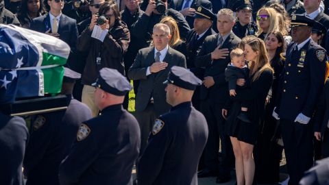 La esposa de Jonathan Diller, Stephanie Diller, besa a su hijo durante el funeral de su esposo.