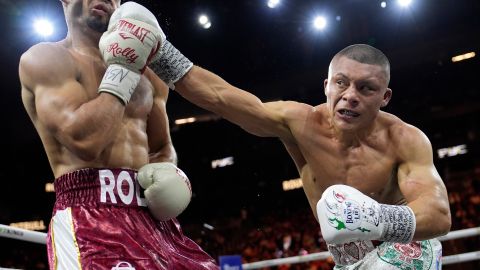 Isaac Cruz, of Mexico, hits Rolando Romero in a super lightweight title bout Saturday, March 30, 2024, in Las Vegas. (AP Photo/John Locher)