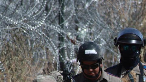 Integrantes de la Guardia Nacional de Texas, vigilan la entrada de migrantes que permanecen en las inmediaciones de la frontera,