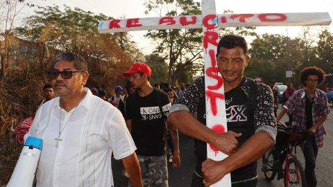 Un migrante sostiene una cruz durante una caravana que se dirige a Ciudad de México.