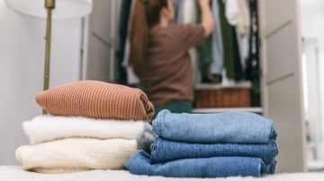 A,Woman,Is,Cleaning,Out,Her,Wardrobe,,Standing,By,Clothes