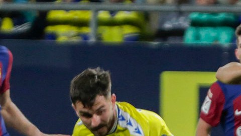 El centrocampista portugués del FC Barcelona, Joao Felix (c), se lleva el balón ante los defensores del Cádiz.