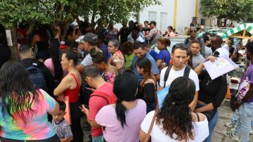Migrantes hacen fila en espera de resolver su situación migratoria en Tapachula, México