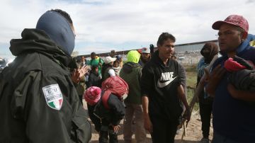Personal del Instituto Nacional de Migración (INM) y un grupo de migrantes dialogan tras un enfrentamiento.