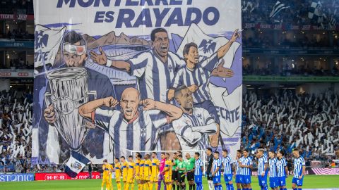 Jugadores de Rayados de Monterrey (d) y Tigres UANL se forman para los actos de protocolo durante el inicio de un partido.