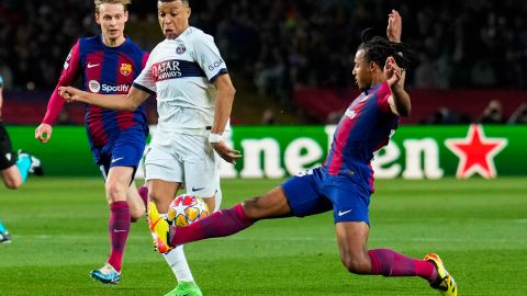 El defensa francés del FC Barcelona, Jules Koundé (d), intenta cortar el avance del delantero del PSG, Kylian Mbappe.