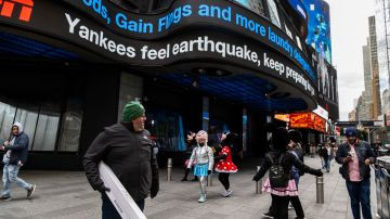 La gente camina por Times Square mientras las noticias mencionan el terremoto de la costa este.