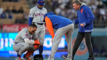 Francisco Álvarez (L) es atendido por el cuerpo médico de New York Mets luego de lesionarse el pulgar izquierdo ante Dodgers.
