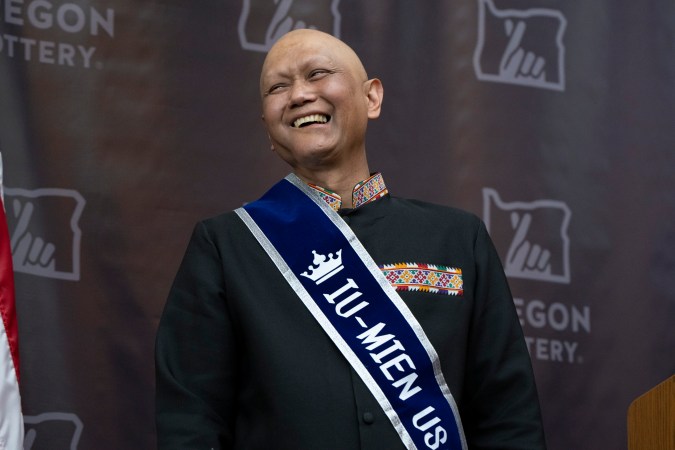 Cheng "Charlie" Saephan señala su banda que dice "Iu-Mien USA" mostrando su herencia de Laos.