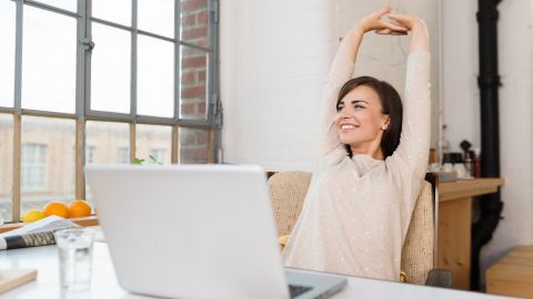 Happy,Relaxed,Young,Woman,Sitting,In,Her,Kitchen,With,A