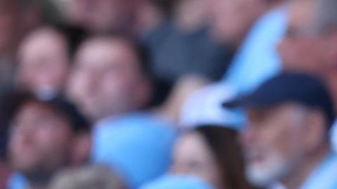 Un hincha del Manchester City sostiene un cartel para celebrar el cuarto título consecutivo de Premier League del equipo ciudadano.