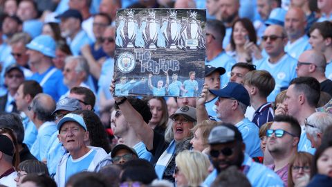 Un hincha del Manchester City sostiene un cartel para celebrar el cuarto título consecutivo de Premier League del equipo ciudadano.