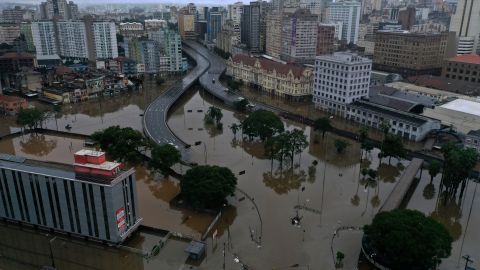 Los vehículos circulan por una carretera lateral restaurada para permitir el movimiento de ayuda humanitaria para los afectados por las inundaciones.