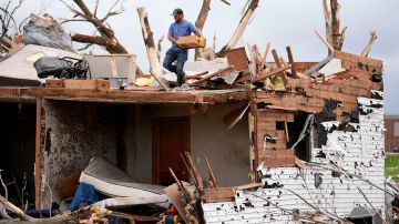Un hombre clasifica los restos de una casa dañada por un tornado el martes 21 de mayo de 2024 en Greenfield, Iowa.