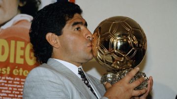 Diego Armando Maradona besa la réplica del Balón de Oro que France Football le hizo entrega en 1995.