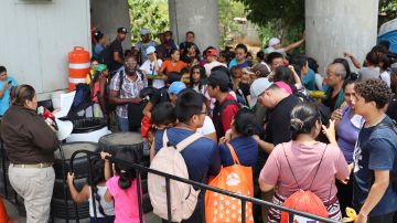 Migrantes permanecen en un punto de revisión del Instituto Nacional de Migración (INM) para entregarse y ser trasladados a Tuxtla Gutiérrez este lunes, en Chiapas (México).