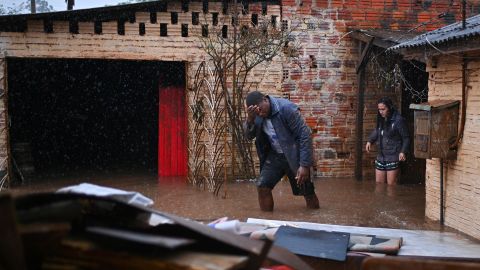 Un hombre camina en el agua que inunda su vivienda este domingo en el municipio de Río Pardo, estado de Rio Grande do Sul (Brasil).