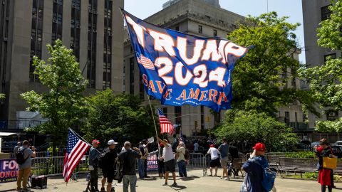 Un partidario del ex presidente estadounidense Donald Trump ondea una enorme bandera en un parque fuera de la Corte Suprema del Estado de Nueva York.