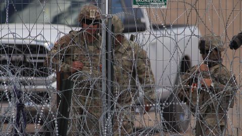 Personal de la Guardia Nacional estadounidense permanecen junto a una cerca de navajas y púas en el muro fronterizo entre México y EEUU, el 19 de mayo de 2024, en Ciudad Juárez, en el estado de Chihuahua (México).