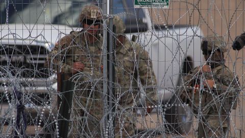 Personal de la Guardia Nacional estadounidense permanecen junto a una cerca de navajas y púas en el muro fronterizo entre México y EEUU, el 19 de mayo de 2024, en Ciudad Juárez, en el estado de Chihuahua (México).