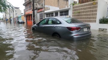 Un vehículo circula por una calle inundada debido a las fuertes lluvias, este martes en Cancún, estado de Quintana Roo, México.