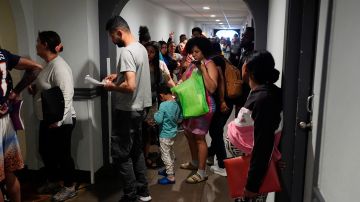 La gente hace cola para ingresar a una sesión de orientación para inmigrantes recientes, el lunes 20 de mayo de 2024, en Denver.