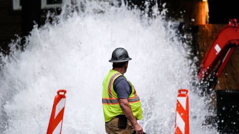 Un miembro de la tripulación camina cerca de una línea de transmisión de agua rota, el sábado 1 de junio de 2024, en Atlanta.