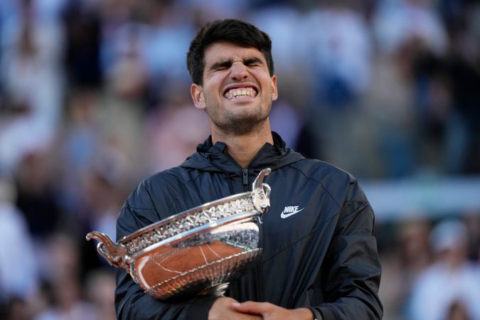 Carlos Alcaraz celebra con el trofeo su victoria en el partido final masculino del Abierto de Francia de tenis contra el alemán Alexander Zverev en el estadio Roland Garros de París, el domingo 9 de junio de 2024. (Foto AP Thibault Camus).