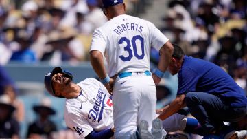 Mookie Betts se queja del dolor mientras es examinado por Dave Roberts y el cuerpo médico de Dodgers.