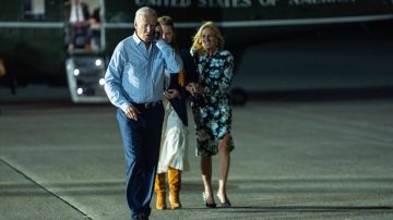 El presidente Joe Biden, izquierda, habla por teléfono mientras camina hacia el Air Force One en la Base de la Fuerza Aérea McGuire.