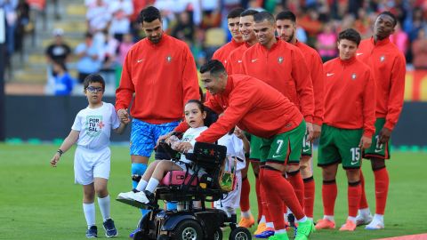 Cristiano Ronaldo comparte con la niña durante la salida de los equipos.