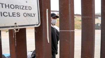 Un migrante espera junto al muro fronterizo, este miércoles en San Ysidro, San Diego (Estados Unidos).