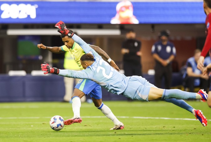 El portero de Costa Rica Patrick Sequeira (d) intenta frenar el avance del delantero de Brasil Rodrygo, durante el encuentro que ambas selecciones disputaron hoy martes correspondiente al grupo D de la Copa América. Foto: Caroline Brehman.