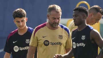 El entrenador alemán del FC Barcelona Hansi Flick (c) y el jugador Ansu Fati (d), durante un entrenamiento del primer equipo.