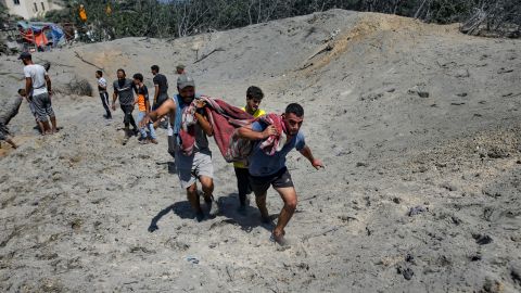 Palestinos evacuan a una persona muerta de un lugar atacado por un bombardeo israelí, en el sur de la Franja de Gaza.