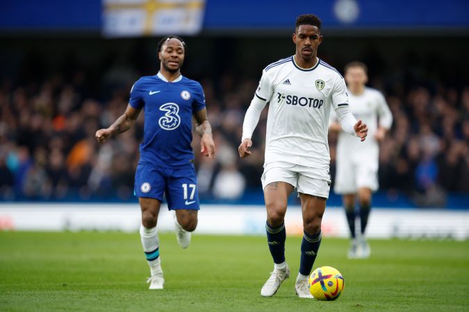 Raheem Sterling del Chelsea, izquierda, y Junior Firpo del Leeds United desafían el balón durante el partido de fútbol de la Premier League inglesa entre Chelsea y Leeds United en el estadio Stamford Bridge de Londres, el sábado 4 de marzo de 2023. (Foto AP/David Cliff).